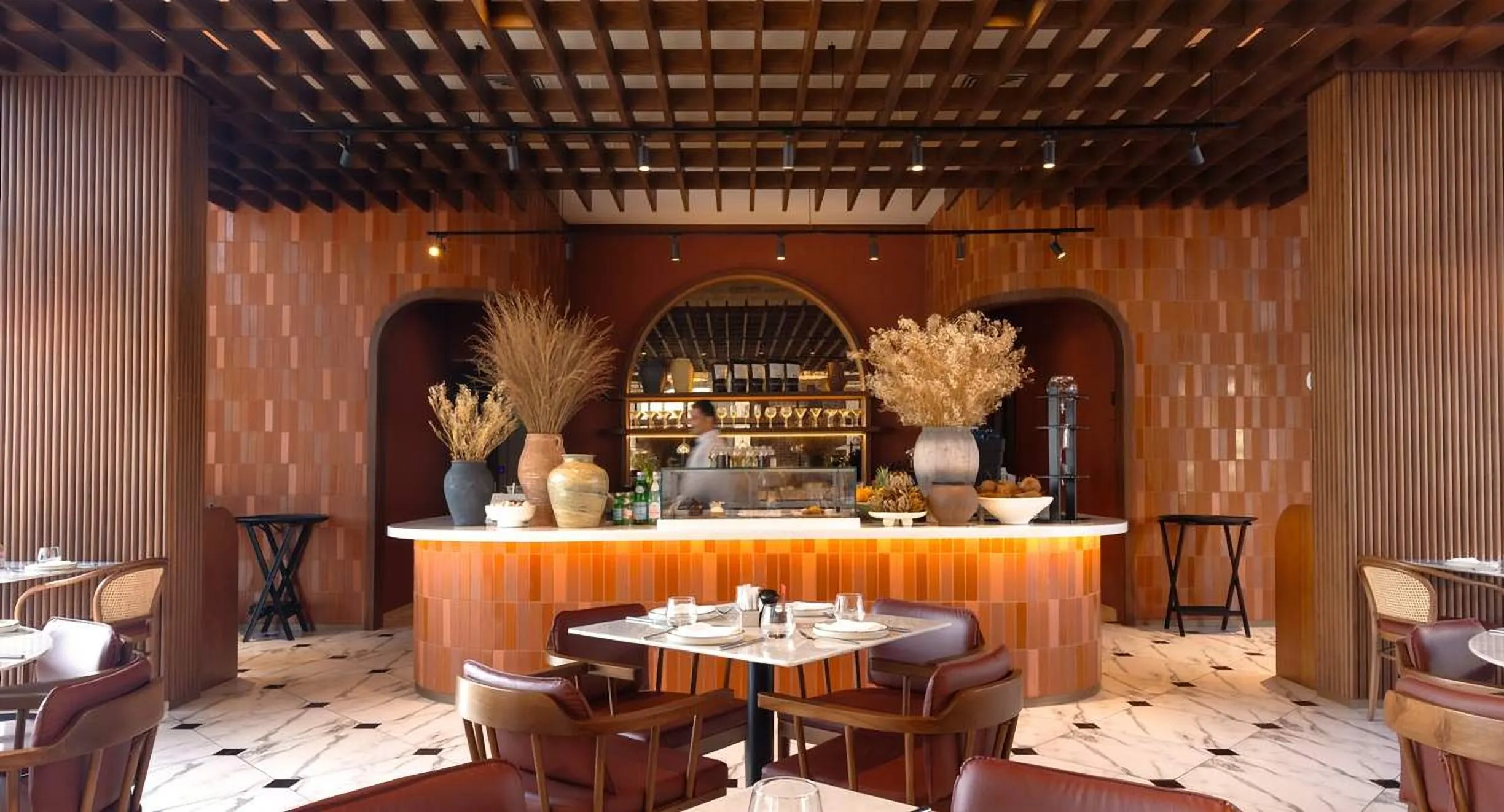 Café with an arched bar, timber ceiling grid and terracotta panels