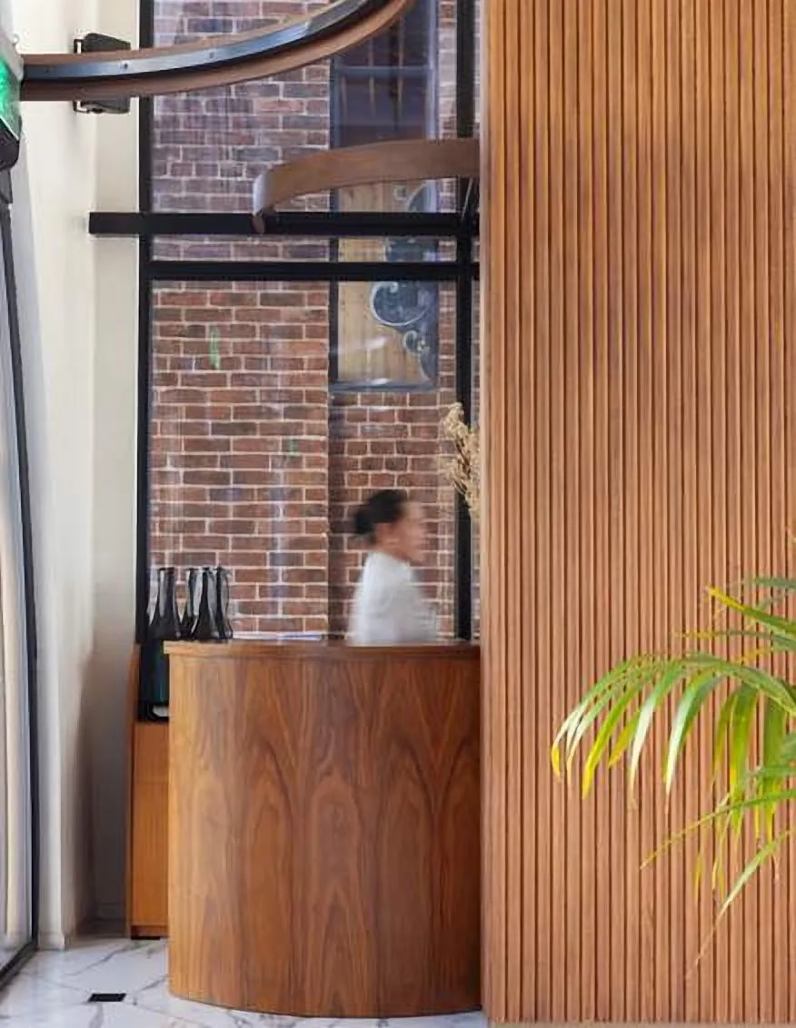 Curved timber host stand beside brick and slatted timber