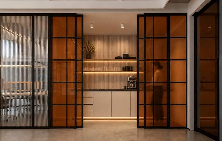 Pantry behind black-framed amber glass sliders
