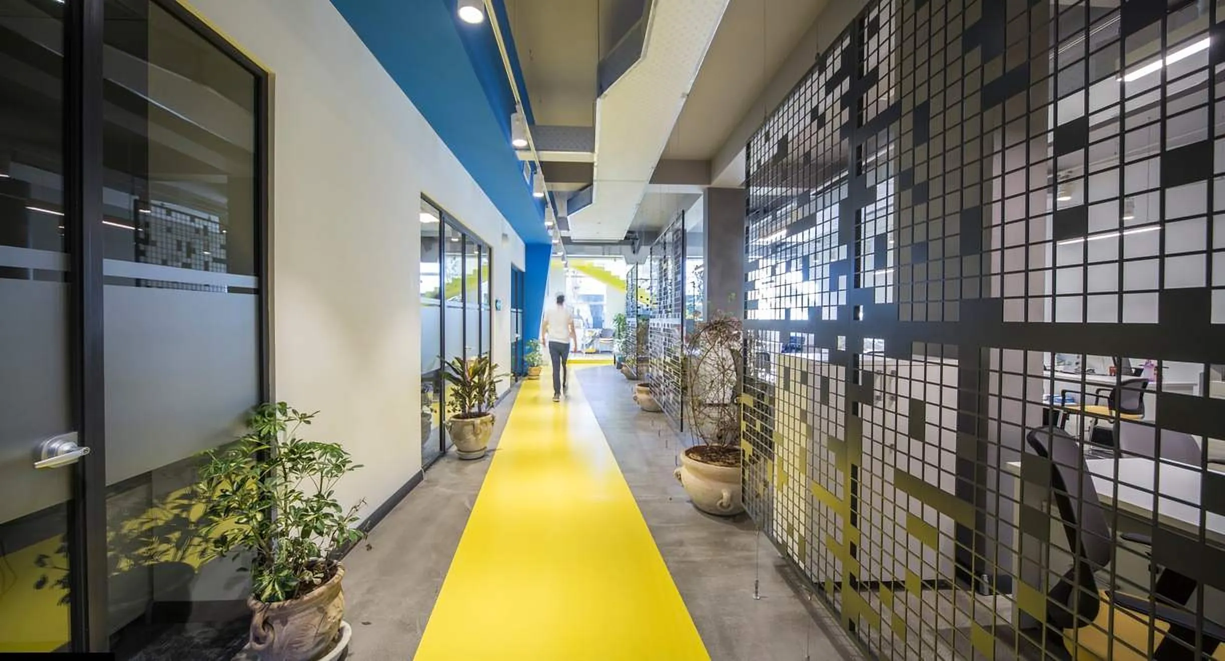 Corridor with a yellow floor stripe and a perforated wall