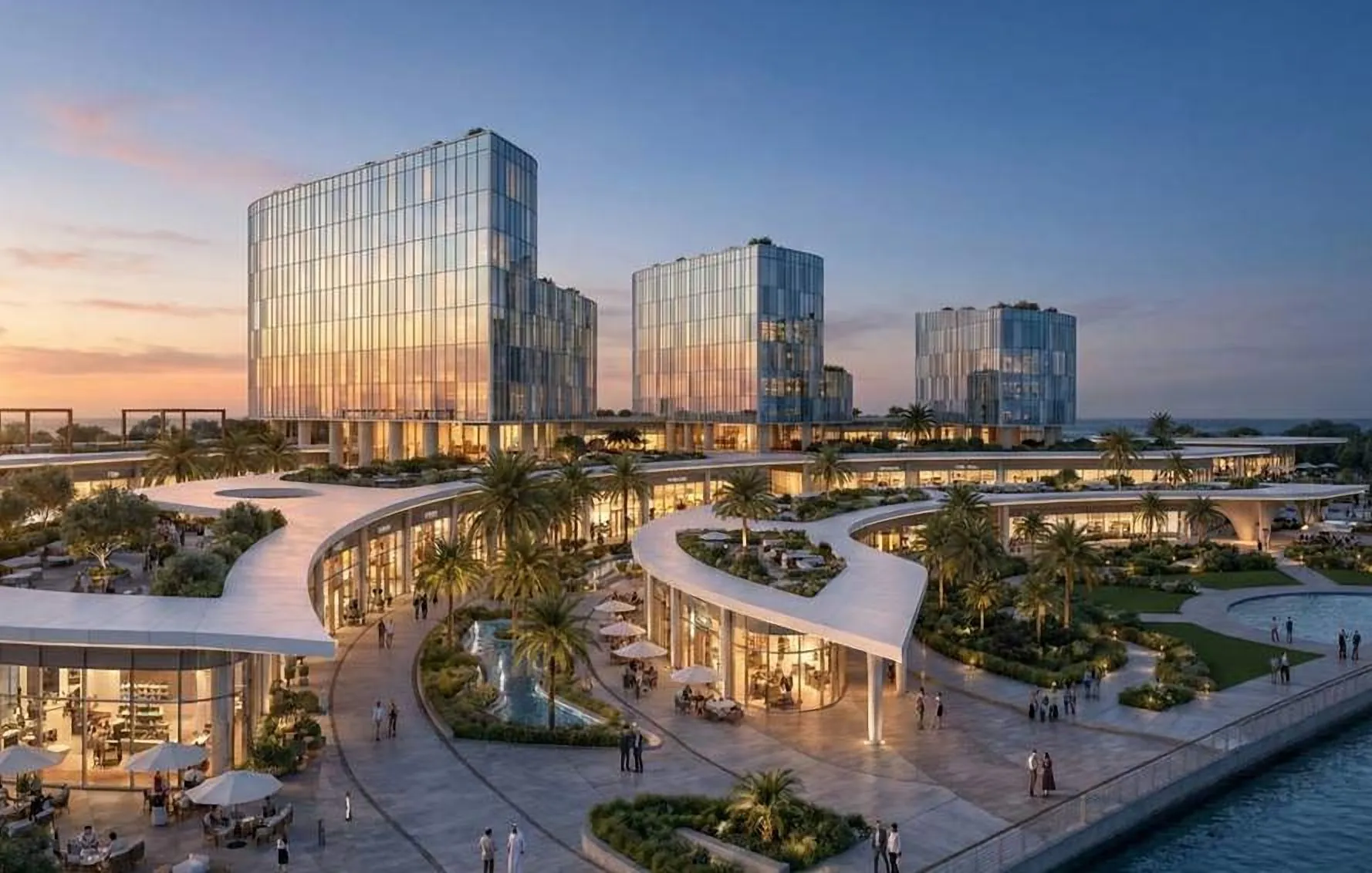 Glass towers above a landscaped podium and promenade at dusk
